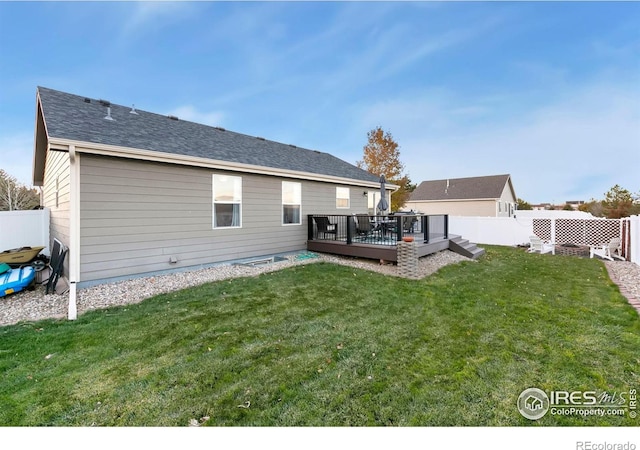 rear view of house with a lawn and a deck