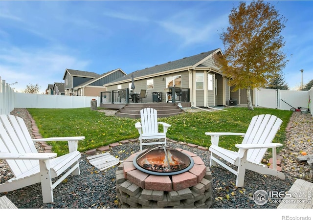 rear view of house featuring central AC, an outdoor fire pit, a lawn, and a wooden deck