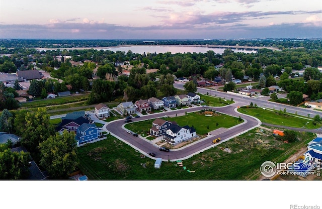 aerial view at dusk featuring a water view