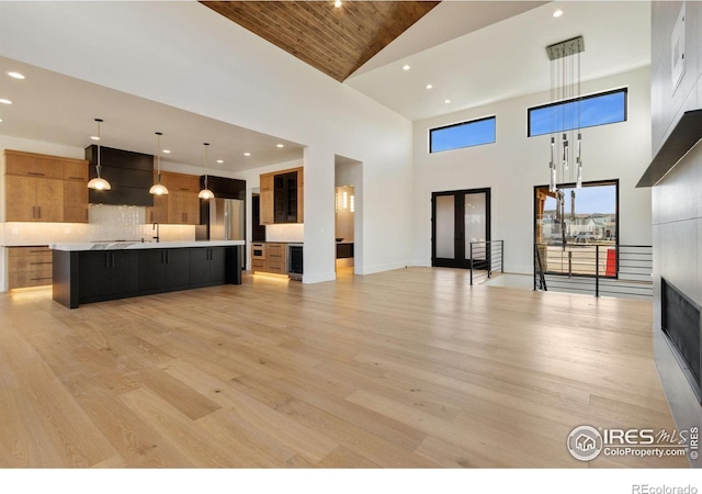 unfurnished living room featuring light hardwood / wood-style flooring, high vaulted ceiling, and wooden ceiling