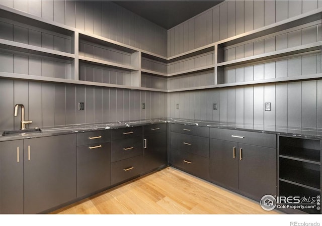 kitchen with dark stone countertops and light wood-type flooring