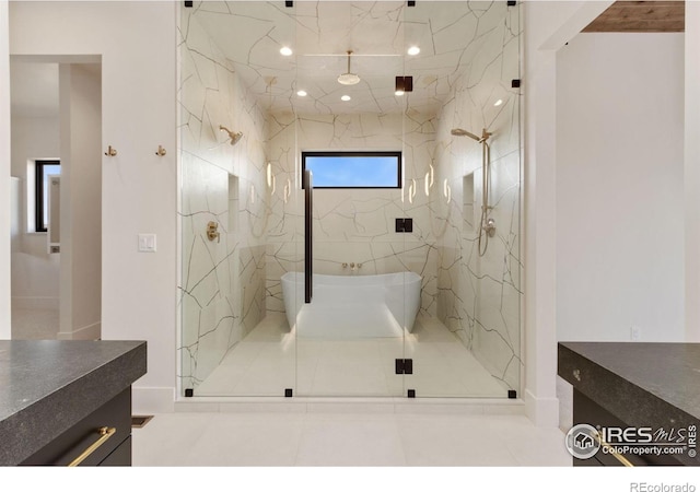 bathroom featuring tile patterned flooring, vanity, an enclosed shower, and tile walls