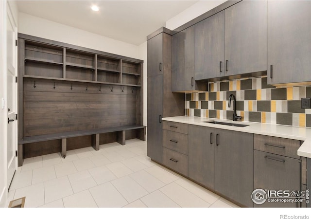 mudroom featuring sink and light tile patterned flooring