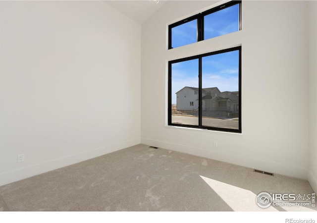 unfurnished room featuring carpet flooring and lofted ceiling