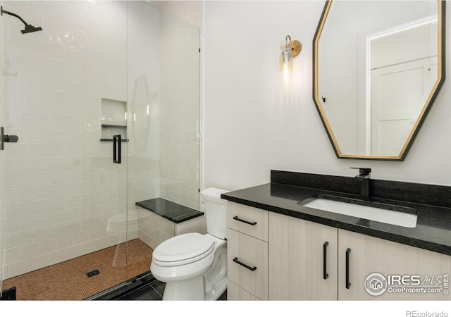 bathroom with vanity, a shower with shower door, and toilet