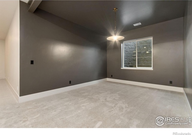 carpeted empty room featuring vaulted ceiling