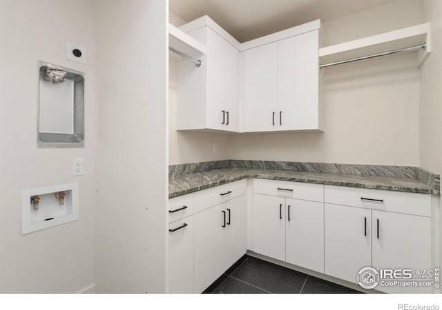 kitchen featuring white cabinets, dark tile patterned floors, and dark stone countertops