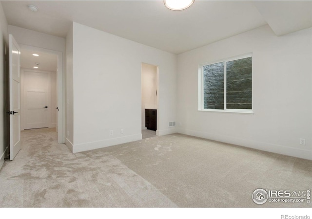 unfurnished room featuring light colored carpet