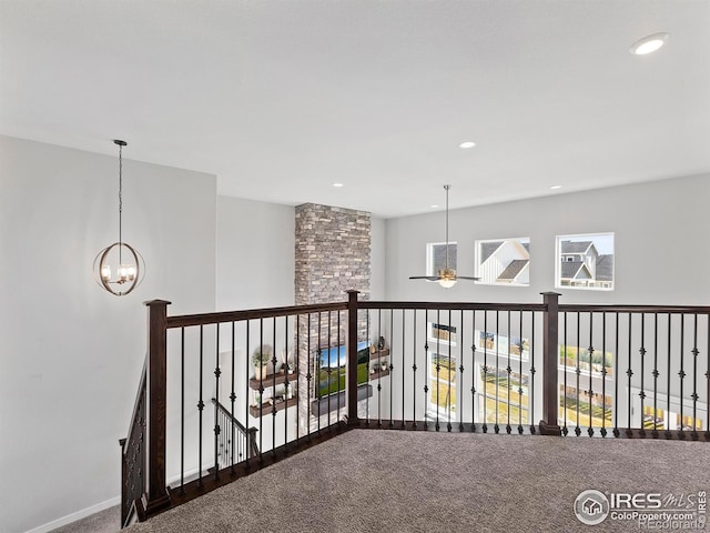 hallway featuring carpet flooring and an inviting chandelier