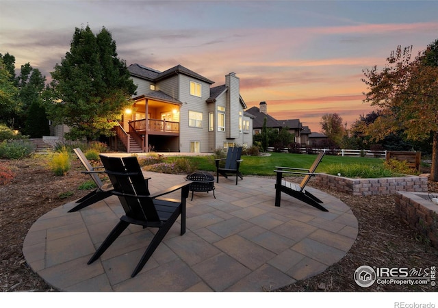 patio terrace at dusk with a yard and an outdoor fire pit