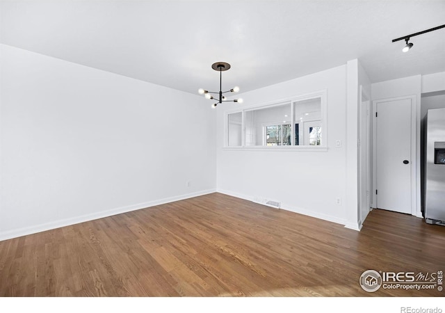 unfurnished dining area featuring hardwood / wood-style floors and an inviting chandelier