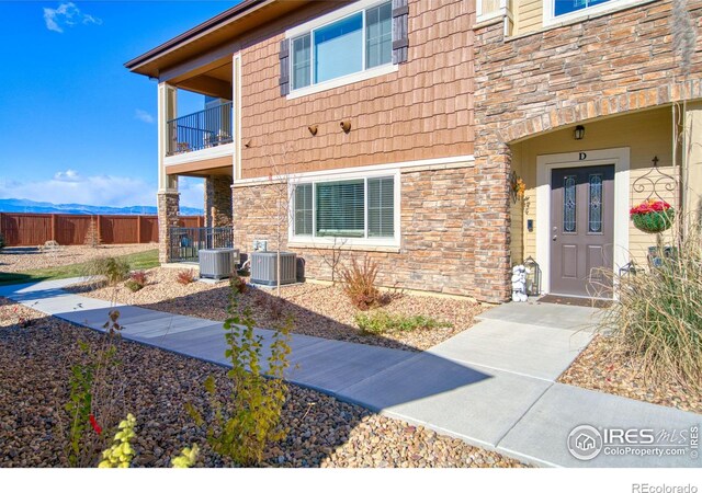 view of exterior entry featuring a balcony and cooling unit