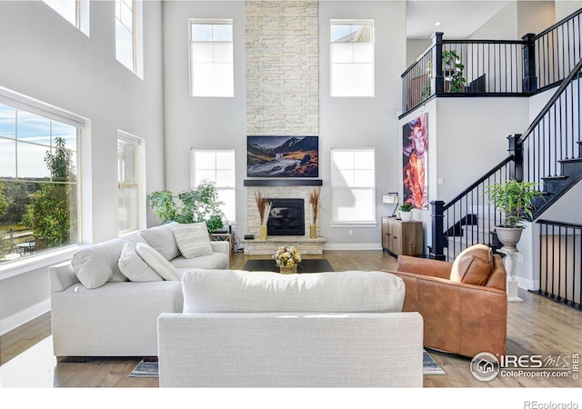 living room with a healthy amount of sunlight, a fireplace, and light hardwood / wood-style flooring