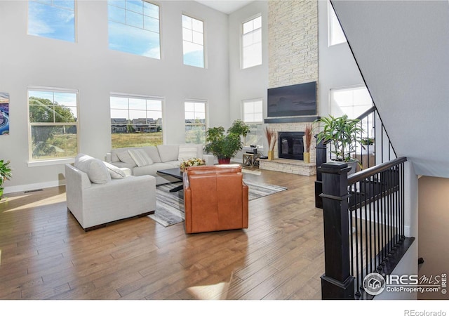 living room featuring a healthy amount of sunlight, a fireplace, and hardwood / wood-style floors