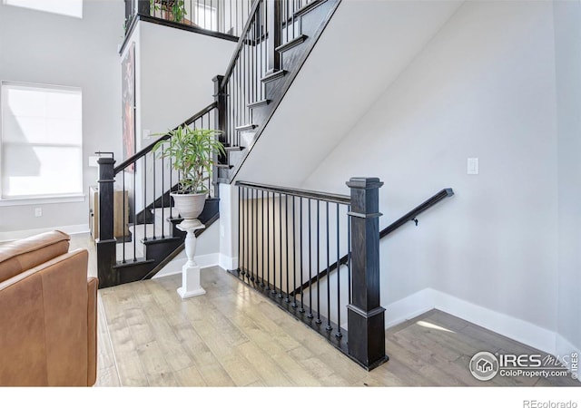 stairway with a high ceiling and hardwood / wood-style floors