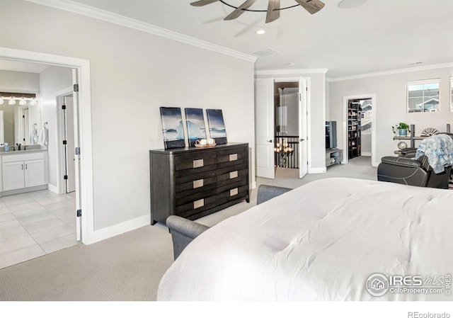 carpeted bedroom with sink, ceiling fan, ensuite bathroom, ornamental molding, and a spacious closet