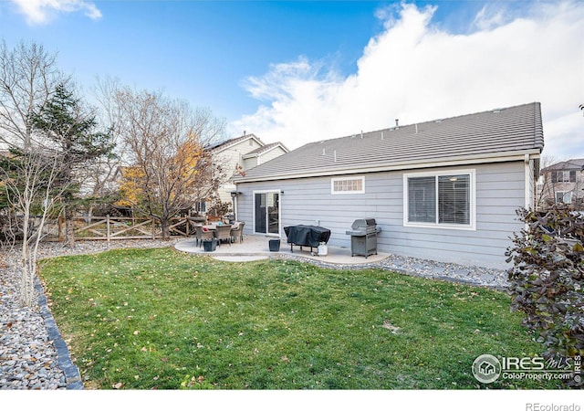 rear view of house featuring a yard and a patio