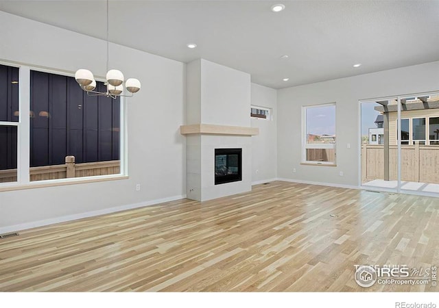 unfurnished living room featuring light hardwood / wood-style floors and a notable chandelier