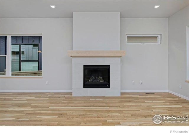 unfurnished living room with a fireplace and light hardwood / wood-style flooring