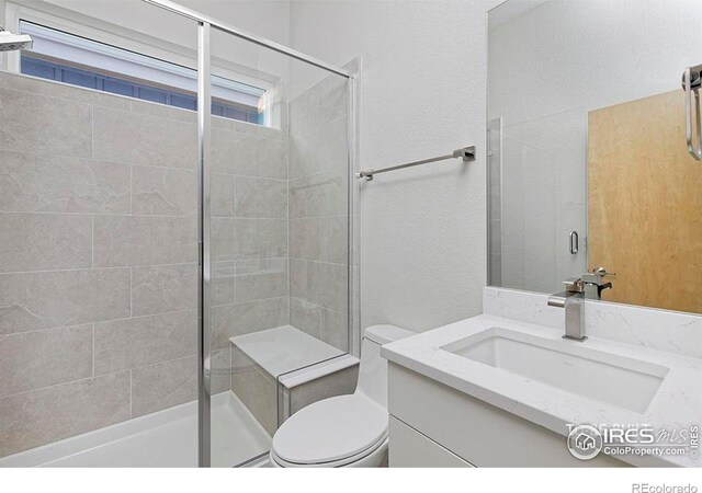2292 Star Hill St, Longmont, CO 80503 - bathroom featuring vanity, a shower stall, toilet, and a textured wall