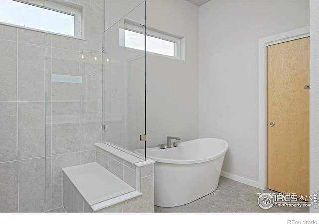 bathroom with tile patterned floors, plenty of natural light, and plus walk in shower