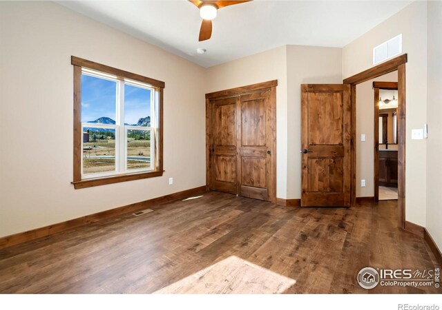 unfurnished bedroom with dark hardwood / wood-style flooring and ceiling fan