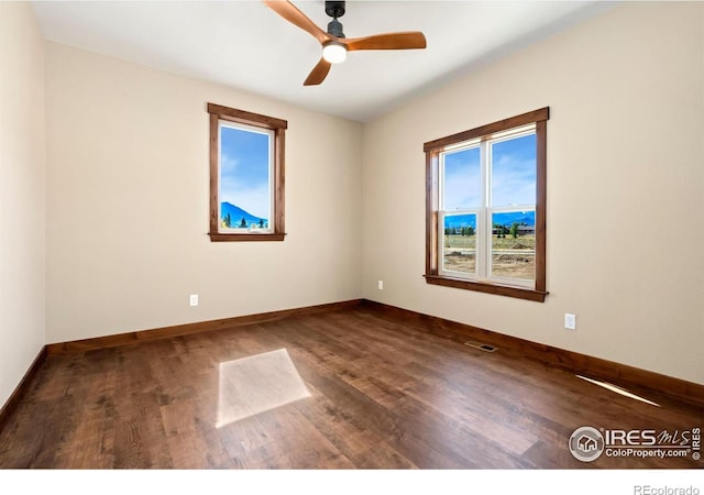 unfurnished room featuring ceiling fan, a healthy amount of sunlight, and dark hardwood / wood-style floors