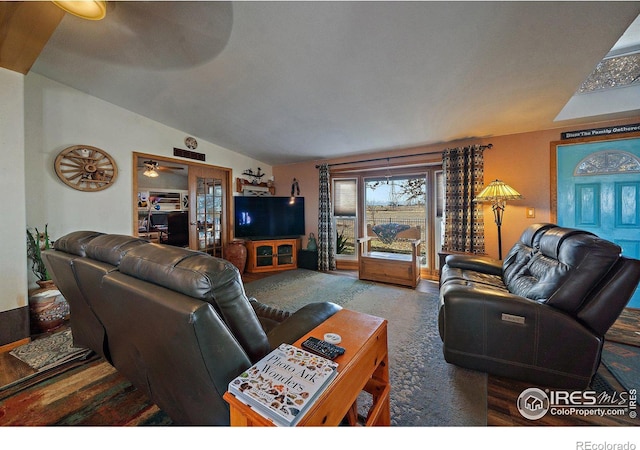 carpeted living room with ceiling fan and lofted ceiling