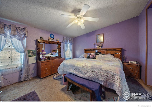 carpeted bedroom featuring ceiling fan, a textured ceiling, and multiple windows