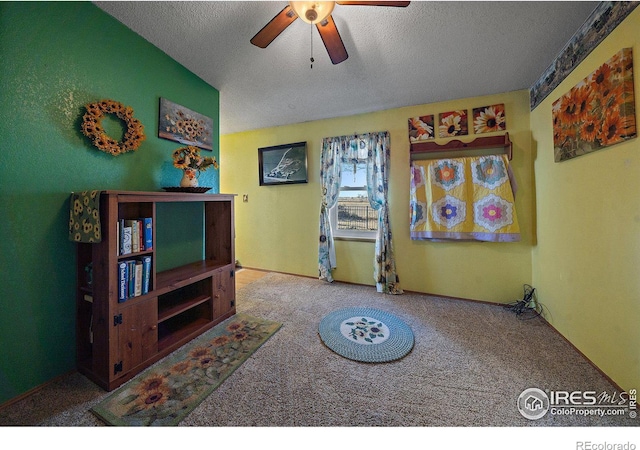 sitting room with carpet, a textured ceiling, and ceiling fan