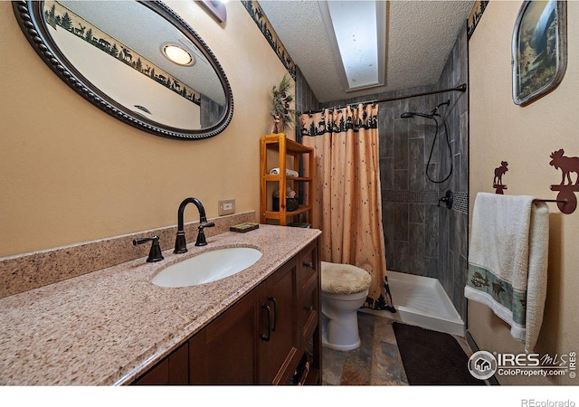 bathroom with a skylight, walk in shower, a textured ceiling, toilet, and vanity