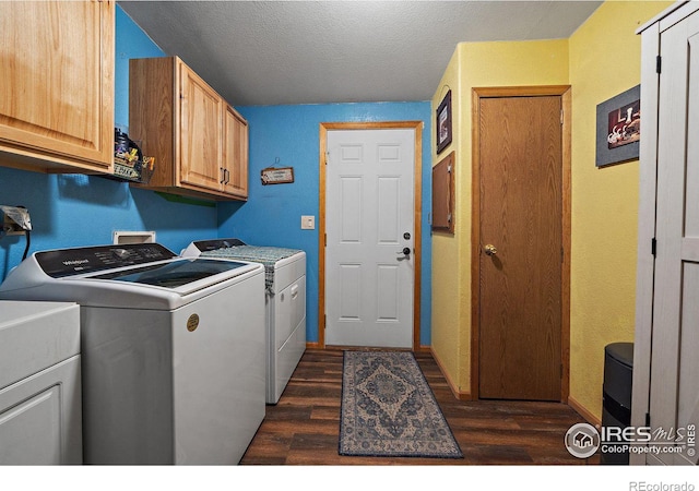 clothes washing area featuring cabinets, dark hardwood / wood-style flooring, a textured ceiling, and washing machine and clothes dryer