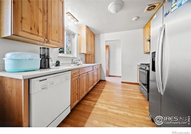 kitchen featuring sink, stainless steel appliances, and light hardwood / wood-style floors