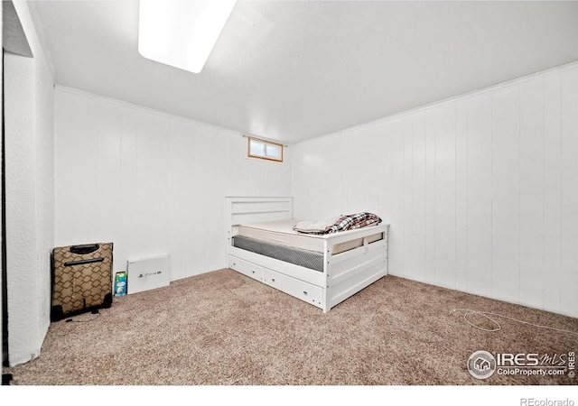 carpeted bedroom featuring wood walls