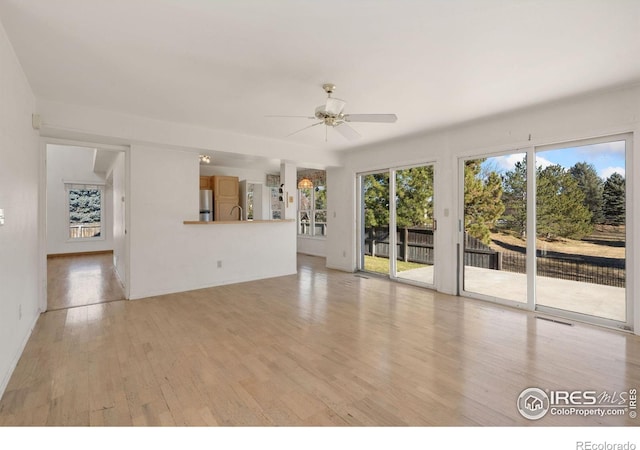 unfurnished living room featuring light wood-type flooring and ceiling fan