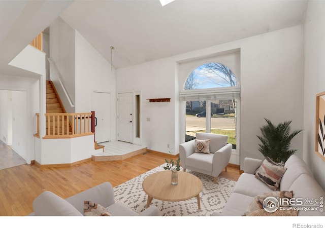 living room with high vaulted ceiling and light hardwood / wood-style floors