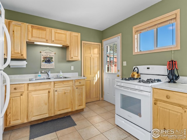 kitchen featuring sink, white appliances, and light brown cabinets