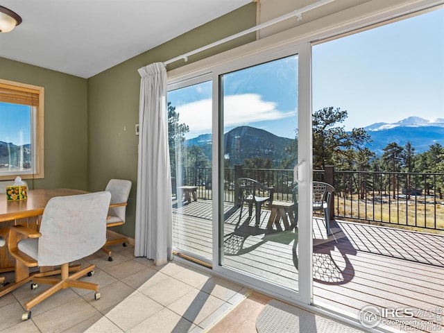 doorway to outside with a mountain view and light tile patterned floors