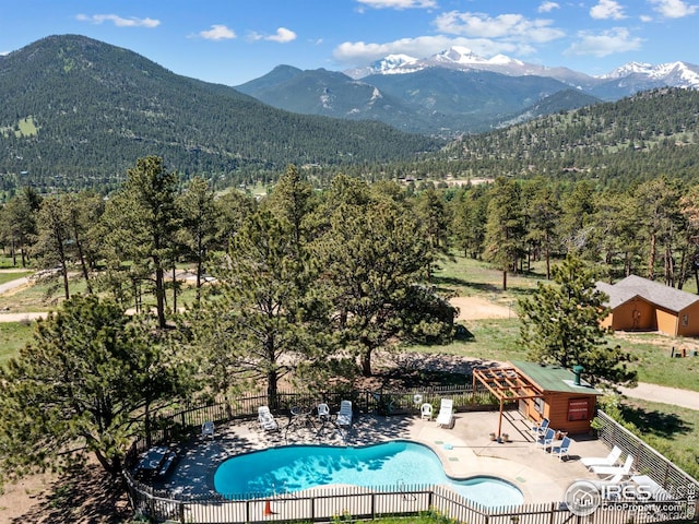 view of swimming pool with a patio and a mountain view