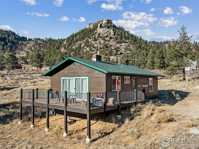 rear view of house featuring a deck with mountain view