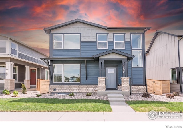 6105 Saddle Horn Dr, Timnath, CO 80547 - view of front of home with brick siding and a yard