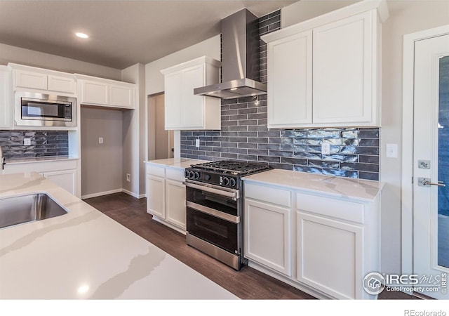 6105 Saddle Horn Dr, Timnath, CO 80547 - kitchen featuring wall chimney exhaust hood, range with two ovens, stainless steel microwave, dark wood-type flooring, and white cabinetry