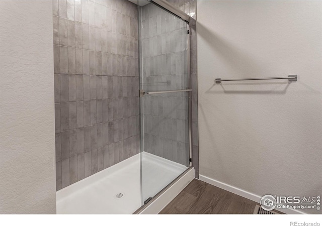 6105 Saddle Horn Dr, Timnath, CO 80547 - full bath featuring wood finished floors, a shower stall, and a textured wall