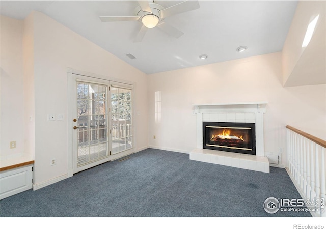 unfurnished living room with carpet flooring, ceiling fan, lofted ceiling, and a tiled fireplace