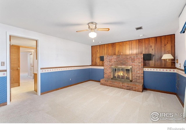 living room featuring light colored carpet, a brick fireplace, and ceiling fan