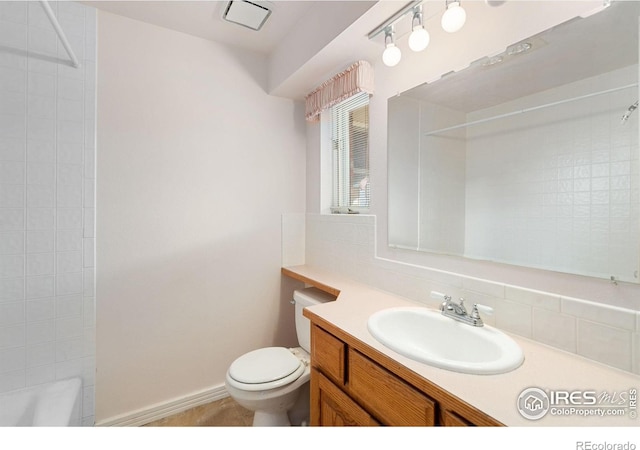 bathroom featuring vanity, toilet, and decorative backsplash