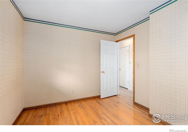 spare room with light hardwood / wood-style flooring and crown molding