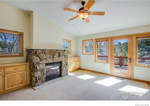 carpeted living room with a fireplace, ceiling fan, and lofted ceiling