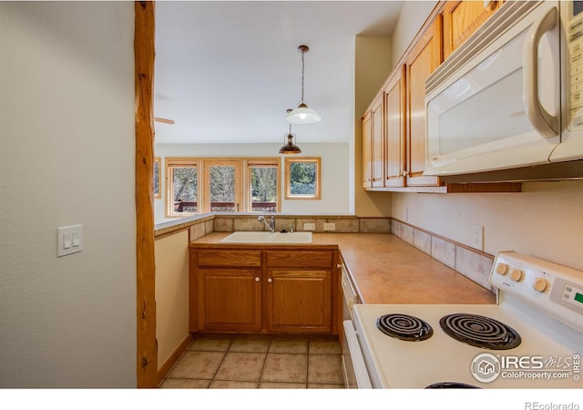 kitchen featuring sink, hanging light fixtures, and white appliances