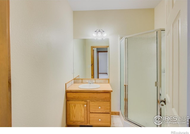 bathroom featuring vanity and an enclosed shower